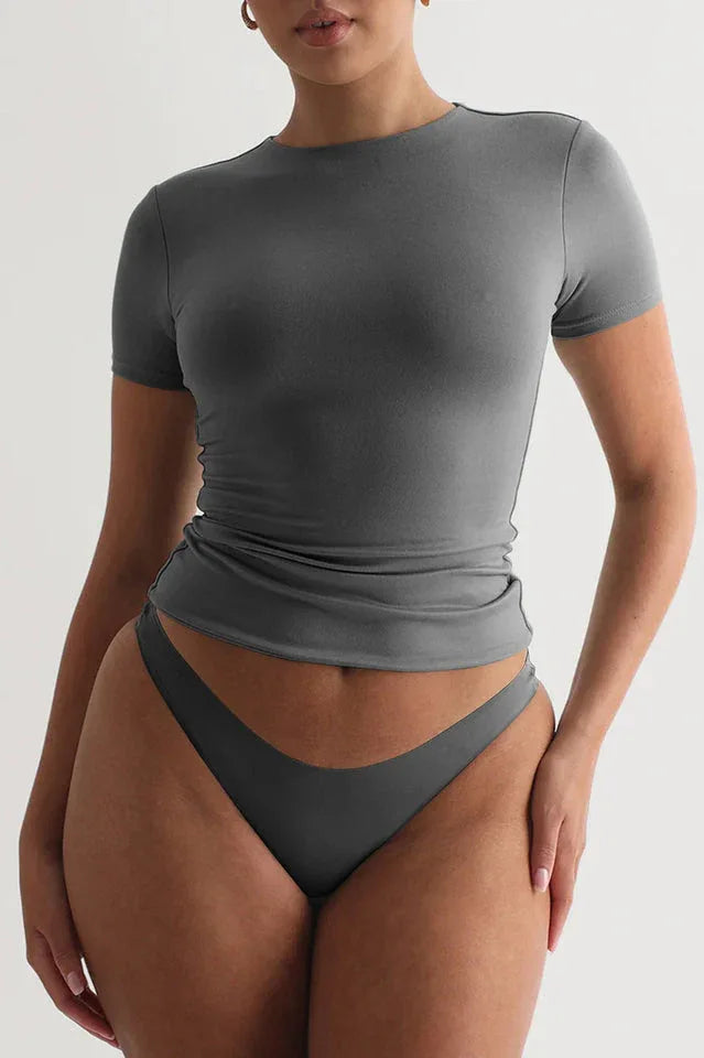 Woman wearing a grey short-sleeve t-shirt and grey underwear