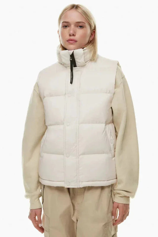 Woman wearing a cream puffer vest over a cream sweatshirt and tan cargo pants
