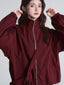 Model wearing a burgundy bomber jacket with a high collar and full zipper closure.