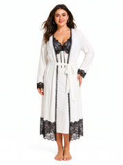 Woman wearing a white satin slip dress with black lace trim and a matching white long robe with black lace trim