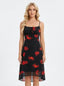 Woman wearing a black sleeveless midi dress with a red floral print and spaghetti straps.