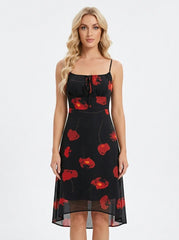 Woman wearing a black sleeveless midi dress with a red floral print and spaghetti straps.