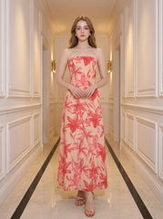 Woman standing in a hallway wearing a strapless floral print midi dress.