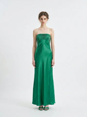 Woman standing in a green strapless satin gown with a pleated bodice, front view