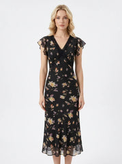 Woman wearing a black floral print midi dress with a v-neckline and short ruffled sleeves.