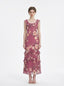 Woman wearing a pink floral print maxi dress with ruffle trim, front view