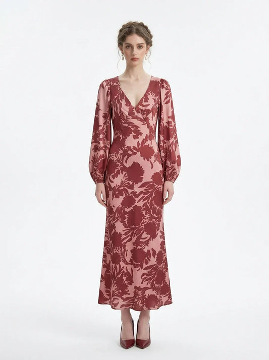 woman wearing a pink and red floral print satin maxi wrap dress with long bishop sleeves and a v-neck, standing against a white background