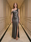 Woman wearing a floor-length grey satin one-shoulder dress with a high slit and bow accents, standing in a hallway.