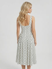 Back view of a woman in a white polka dot dress