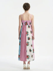 back view of a woman in a pink, blue, and white floral print maxi dress with spaghetti straps, standing against a white background