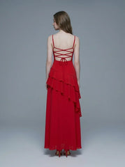 Woman wearing a red floor-length chiffon dress with tiered ruffles and spaghetti straps, back view showing lace-up detail.