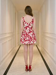 Back view of a woman in a red and white floral print dress and red strappy heels