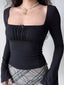 Close-up of a black long-sleeved top with a square neckline and ruching detail on the bust.