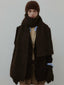 Model wearing a brown fuzzy hat, scarf, jacket, and gloves