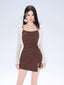 Woman wearing a brown ruched mini dress with a white sheer overlay and large white earrings.
