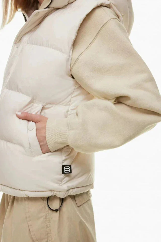 Close-up of the side pocket of a cream puffer vest worn by a woman