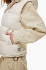 Close-up of the side pocket of a cream puffer vest worn by a woman