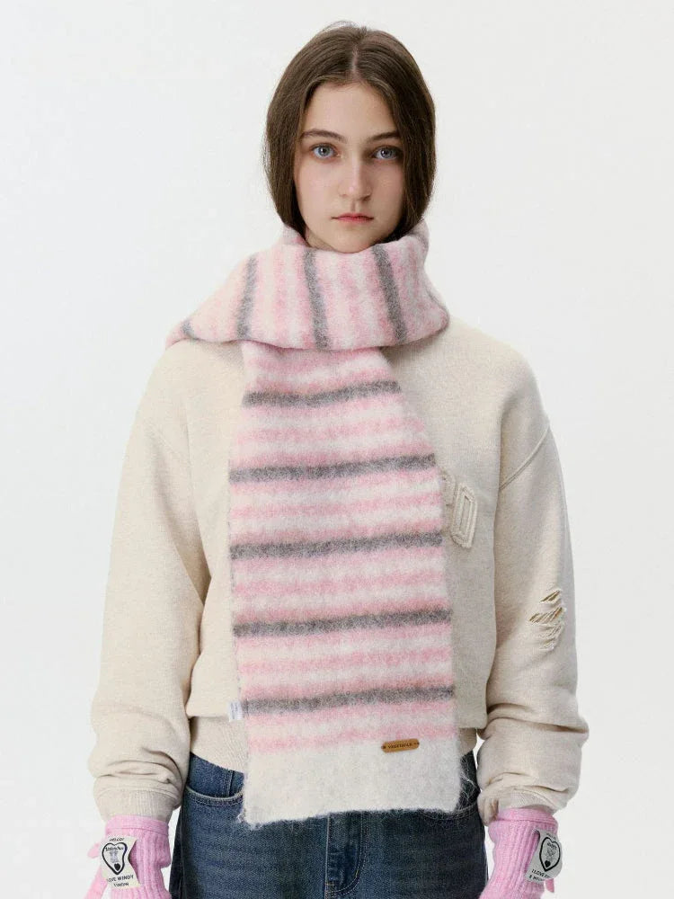 Woman wearing a pink and grey striped fuzzy scarf