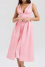 Woman wearing a pink midi dress with a deep V-neck and pleated skirt.