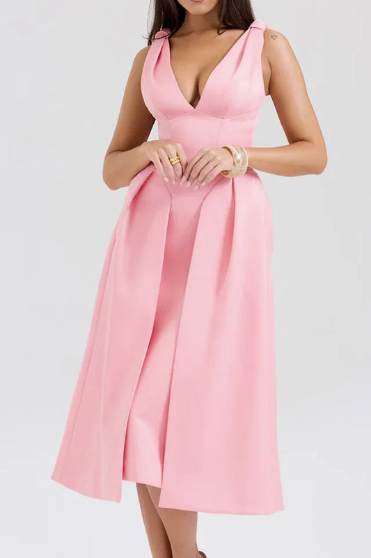 Woman wearing a pink midi dress with a deep V-neck and pleated skirt.