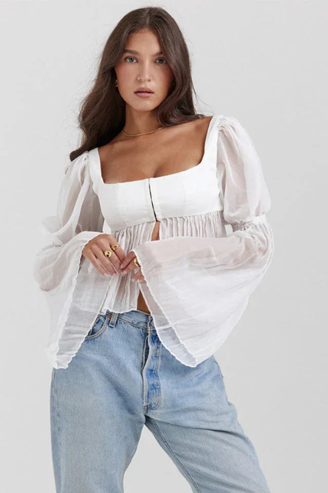 Woman wearing a white cropped blouse with a square neckline and sheer bell sleeves