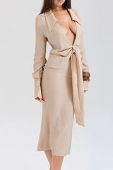 Side view of a woman in a beige linen blend outfit featuring a tie-front top and midi skirt.