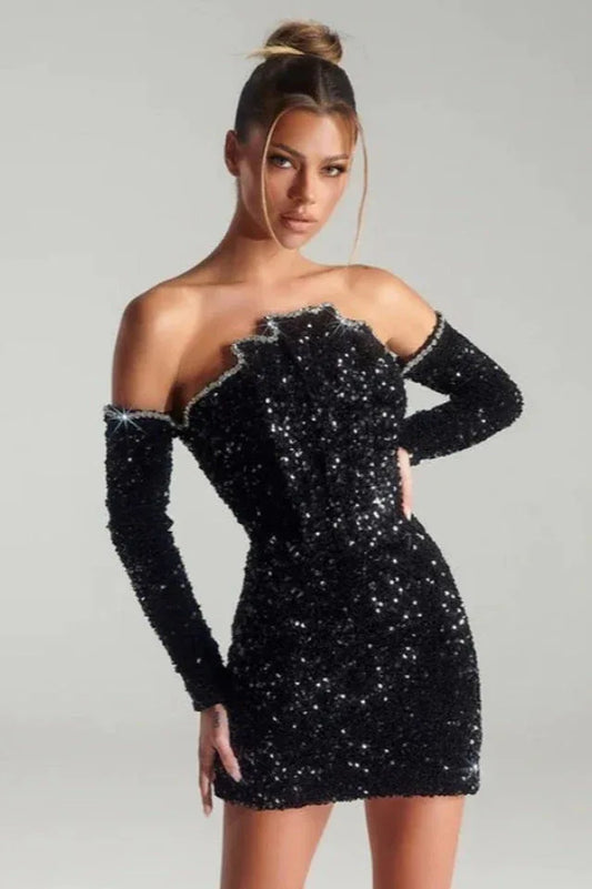 Woman wearing a black sequined off-the-shoulder mini dress with long sleeves.