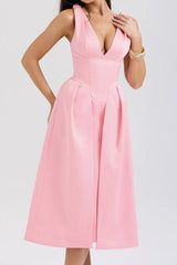 Front view of a woman in a pink sleeveless formal dress.