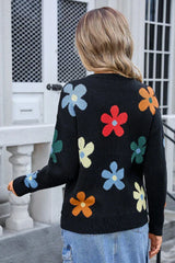 Back view of a woman wearing a black long-sleeve sweater with a colorful floral print.