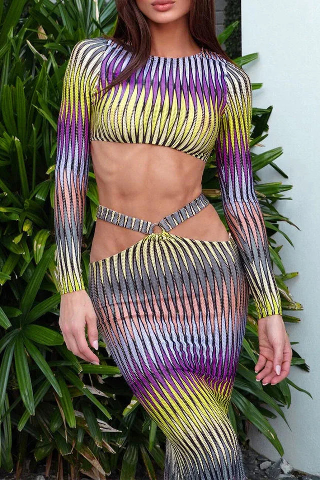 Close-up of a woman wearing a long sleeve crop top and maxi skirt with abstract print and cut-out details