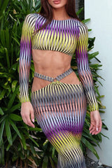 Close-up of a woman wearing a long sleeve crop top and maxi skirt with abstract print and cut-out details