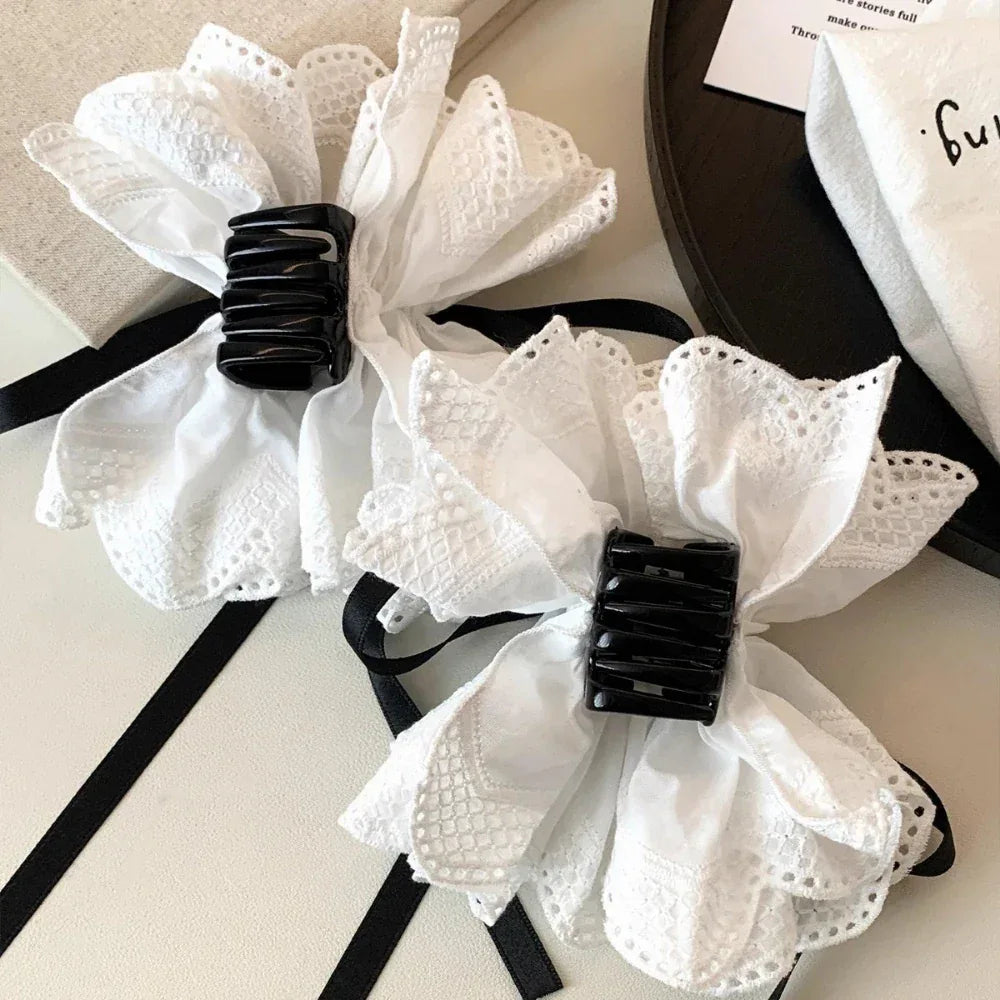 pair of white lace hair clips with black rectangular details