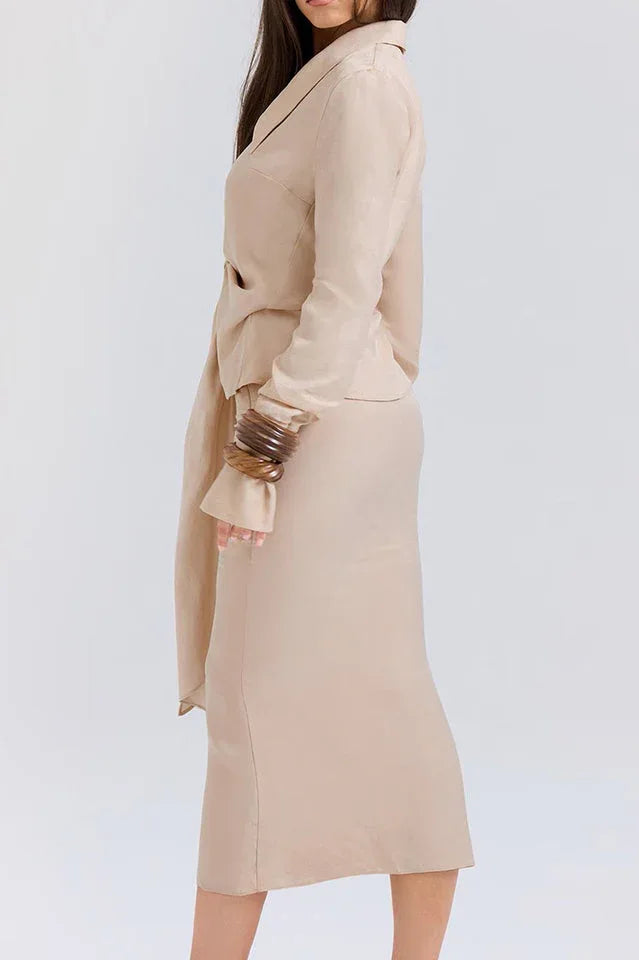 Back view of a woman wearing a beige linen blend long-sleeved top and midi skirt.