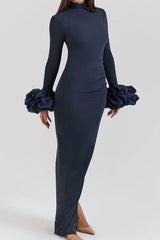 Side view of a navy blue long-sleeved column gown with a high slit and ruffled cuffs.