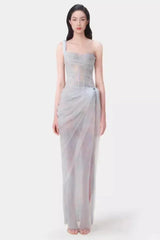 Model wearing a light blue sheer tulle gown with a one-shoulder design and corset bodice.
