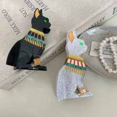 Black and white glitter Egyptian cat hair clips on a book with pearls