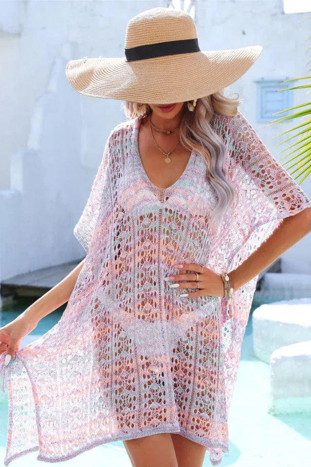 Woman wearing a pastel multi-colored crochet knit kaftan cover-up from the chest up.