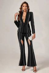 Woman in a black suit with cut-out details and decorative trim, posing with hand on hip.