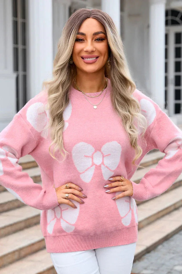 woman in a pink bow print sweater with hands on hips