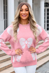 woman in a pink bow print sweater with hands on hips