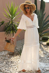Close-up of a woman wearing a white lace-trimmed maxi dress, showing the V-neckline and lace details.