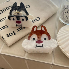 Close-up of two cartoon chipmunk face hair claw clips on a fabric bag
