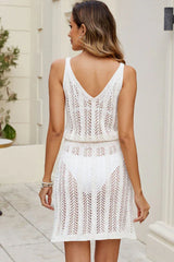 Back view of a woman wearing a white crocheted knit sleeveless V-neck dress with an elasticated waistband