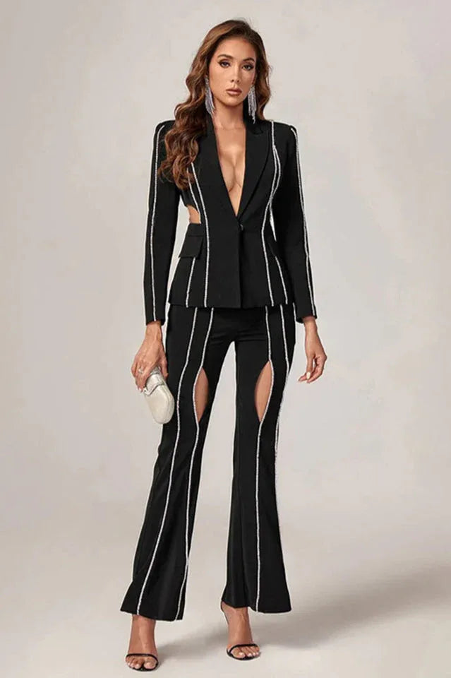 Woman in a black suit with cut-out details and decorative trim, holding a clutch.