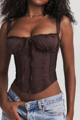 Close-up of the bust area of a brown satin corset top with lace trim