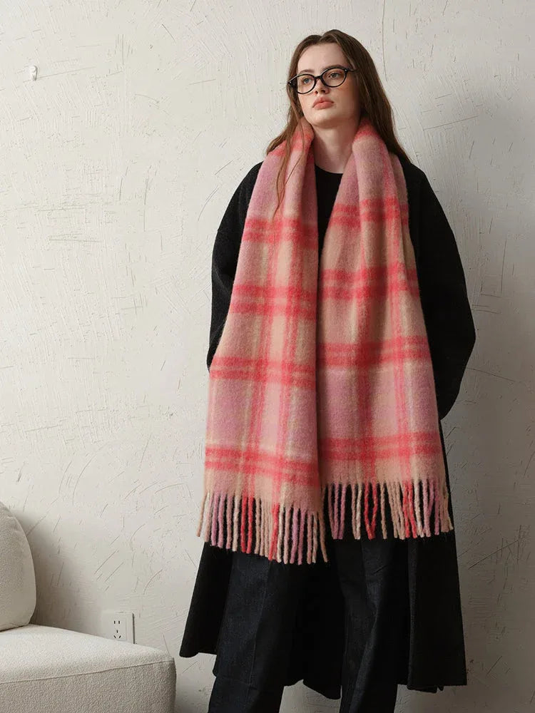 Woman wearing a black coat and a pink plaid scarf, showing the full length of the scarf.