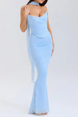 Close-up of a woman wearing a light blue strapless ruched mesh gown with a flowing scarf detail, emphasizing the texture and fit.