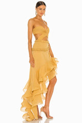 woman posing in a yellow strapless dress with a ruffled hem and cut-out detail
