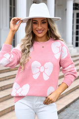 woman in a pink bow print sweater and white hat