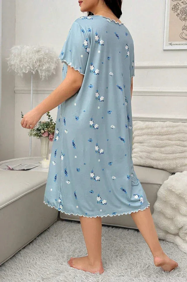 Rear view of a woman wearing a light blue floral print nightgown with scalloped trim.